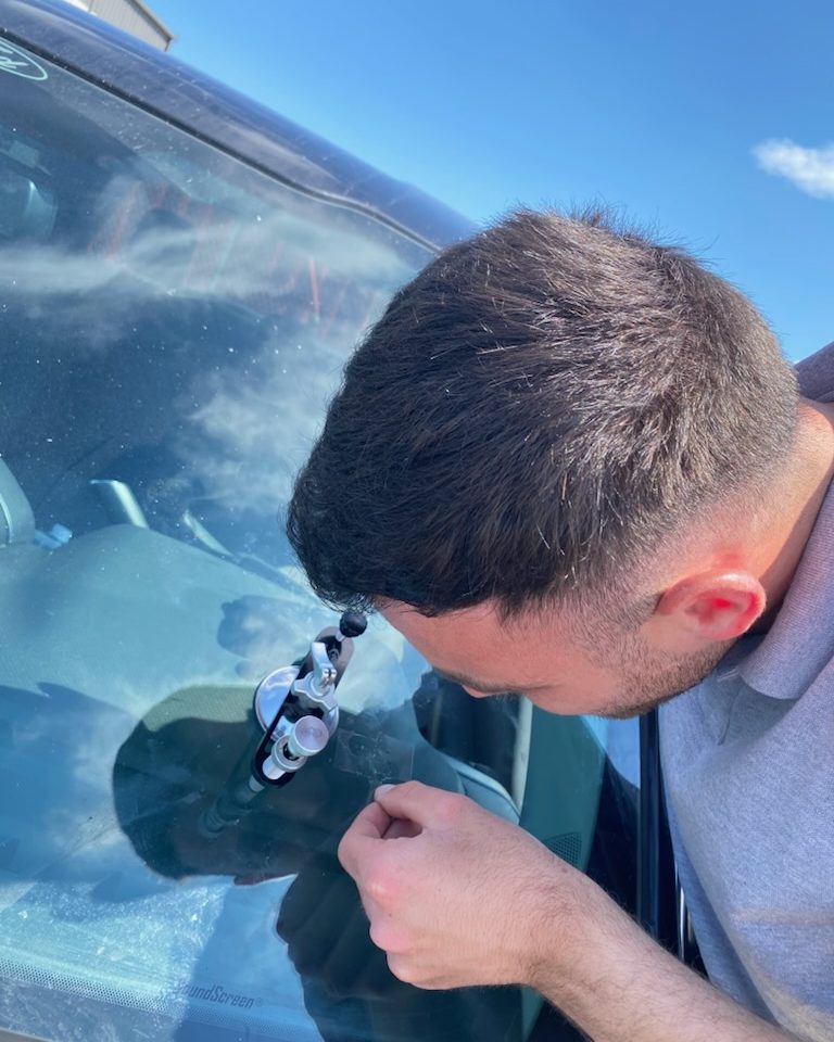 NS Auto Glass technician injecting resin into a windshield rock chip